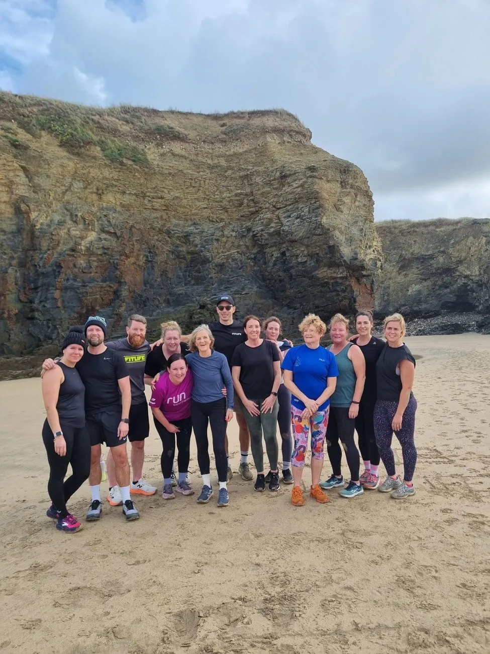 RØAM guests together on the beach beneath the cliffs