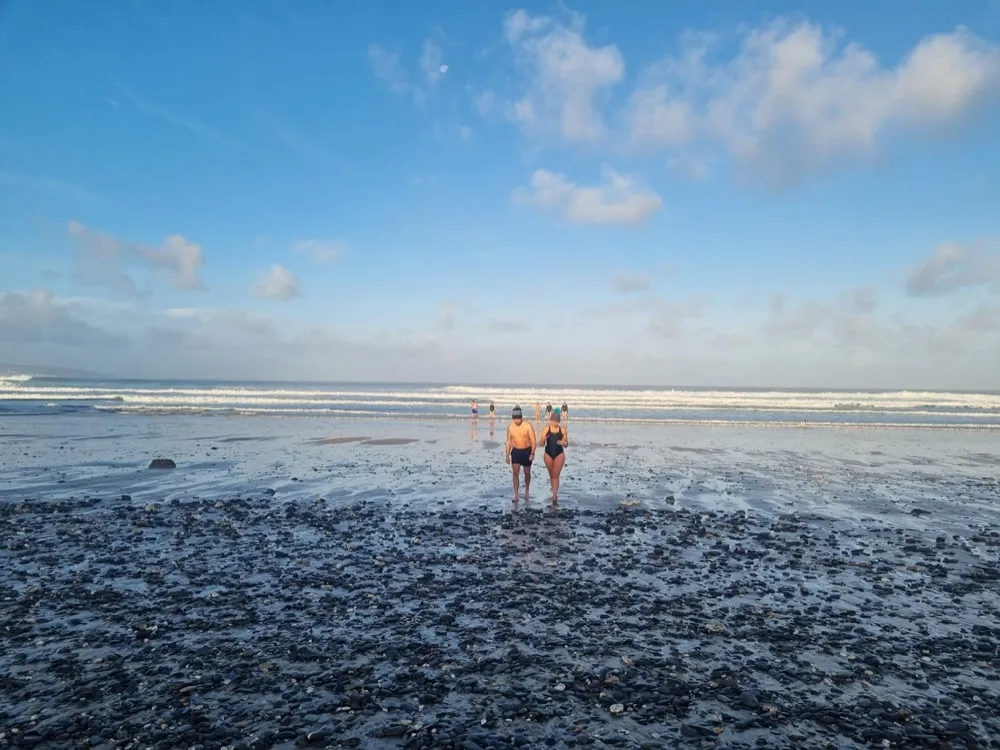 Two guests walking out of the sea after a morning dip